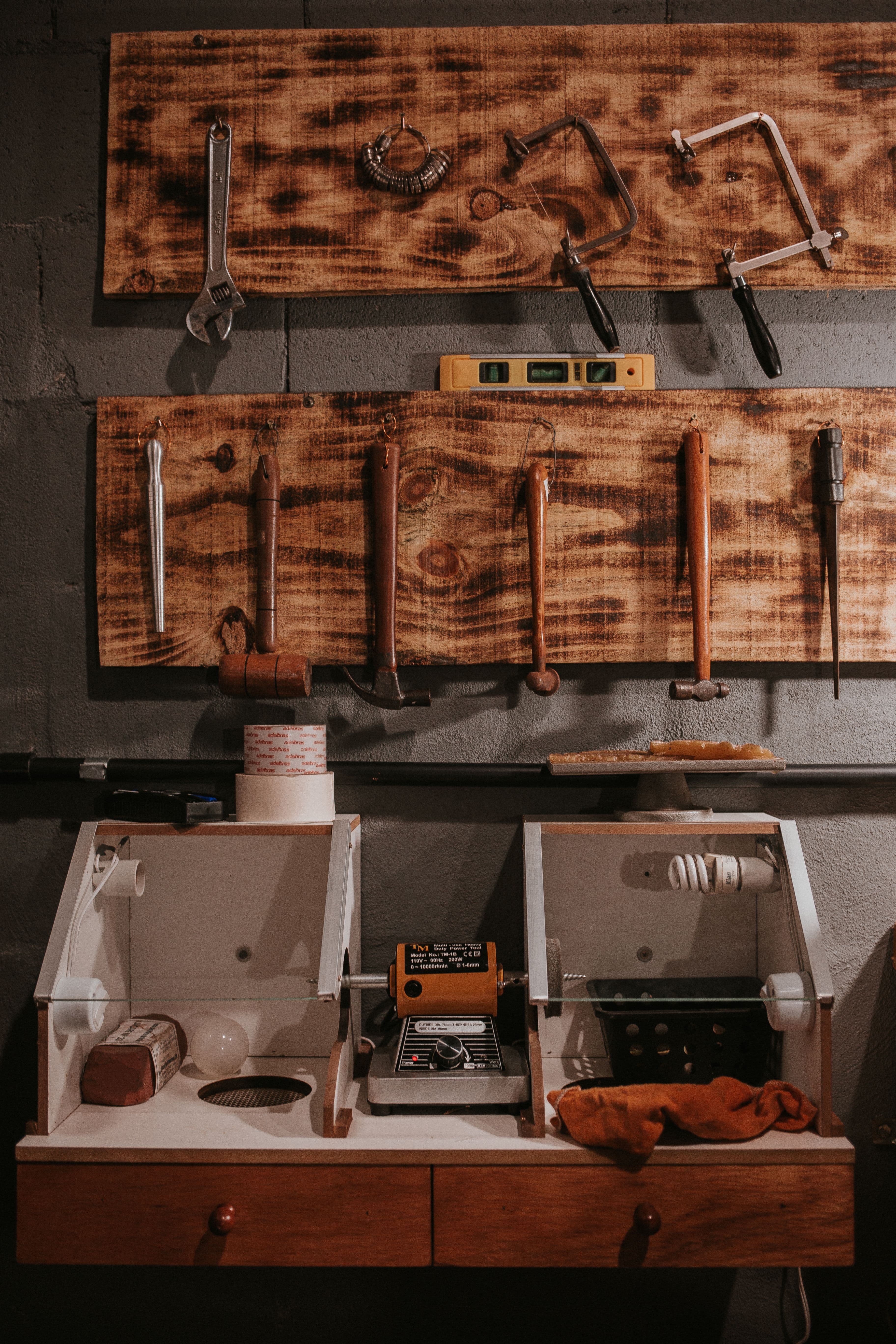 Organized wall display of gunsmithing hand tools above a workbench.