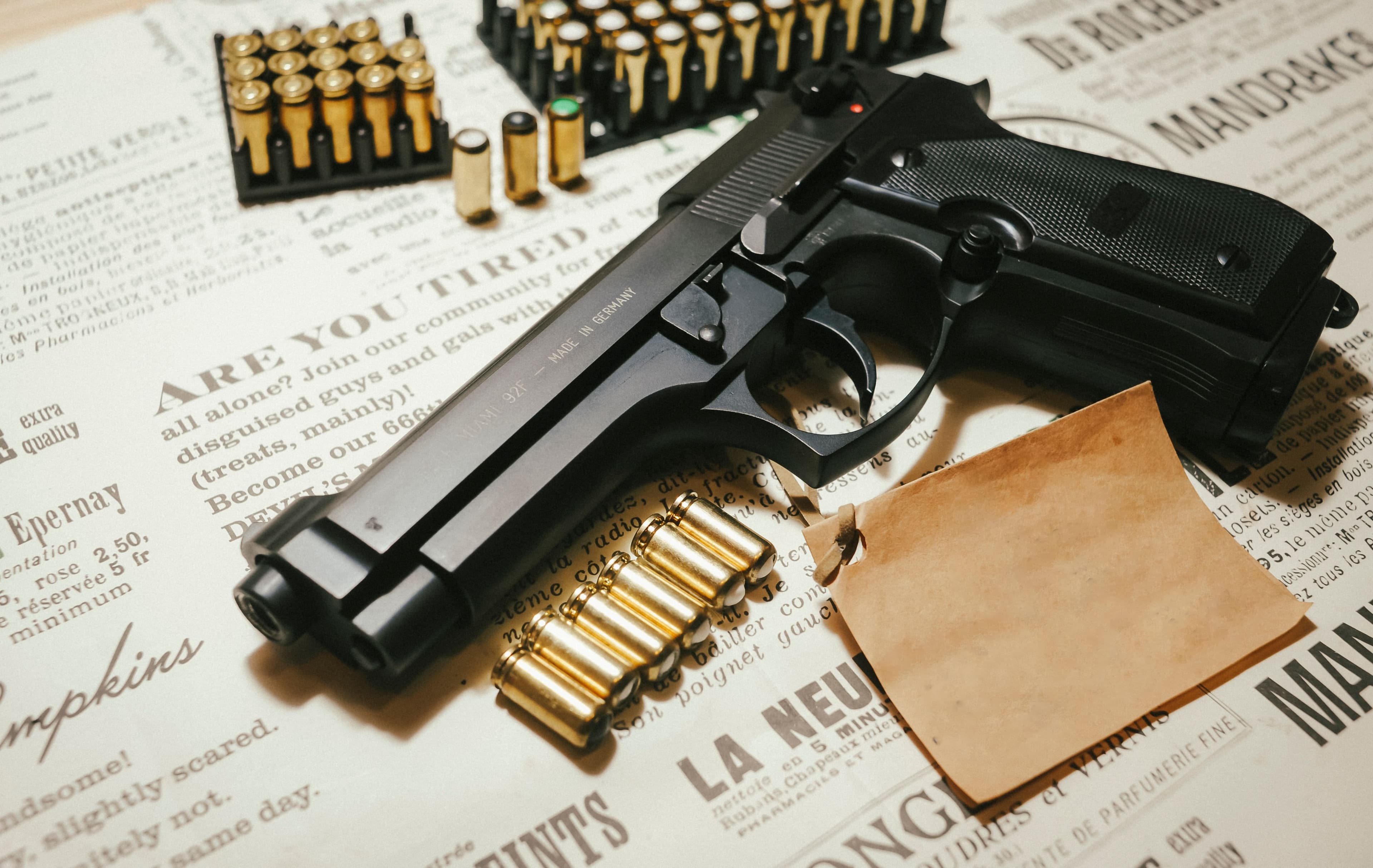 A pistol surrounded by loose brass ammunition in a styled flat lay.