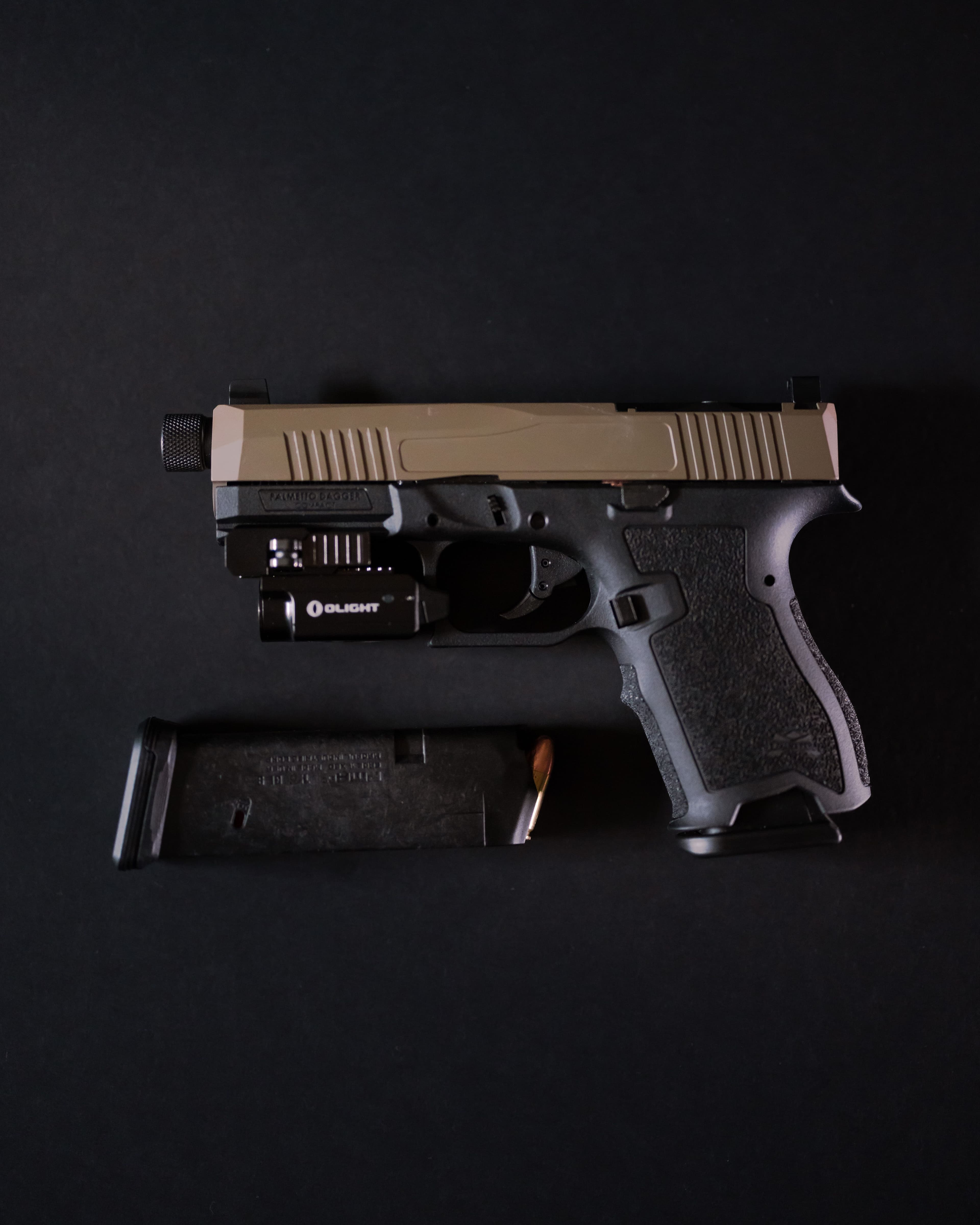 Semi-automatic pistol fitted with a weapon light beside an extended magazine.