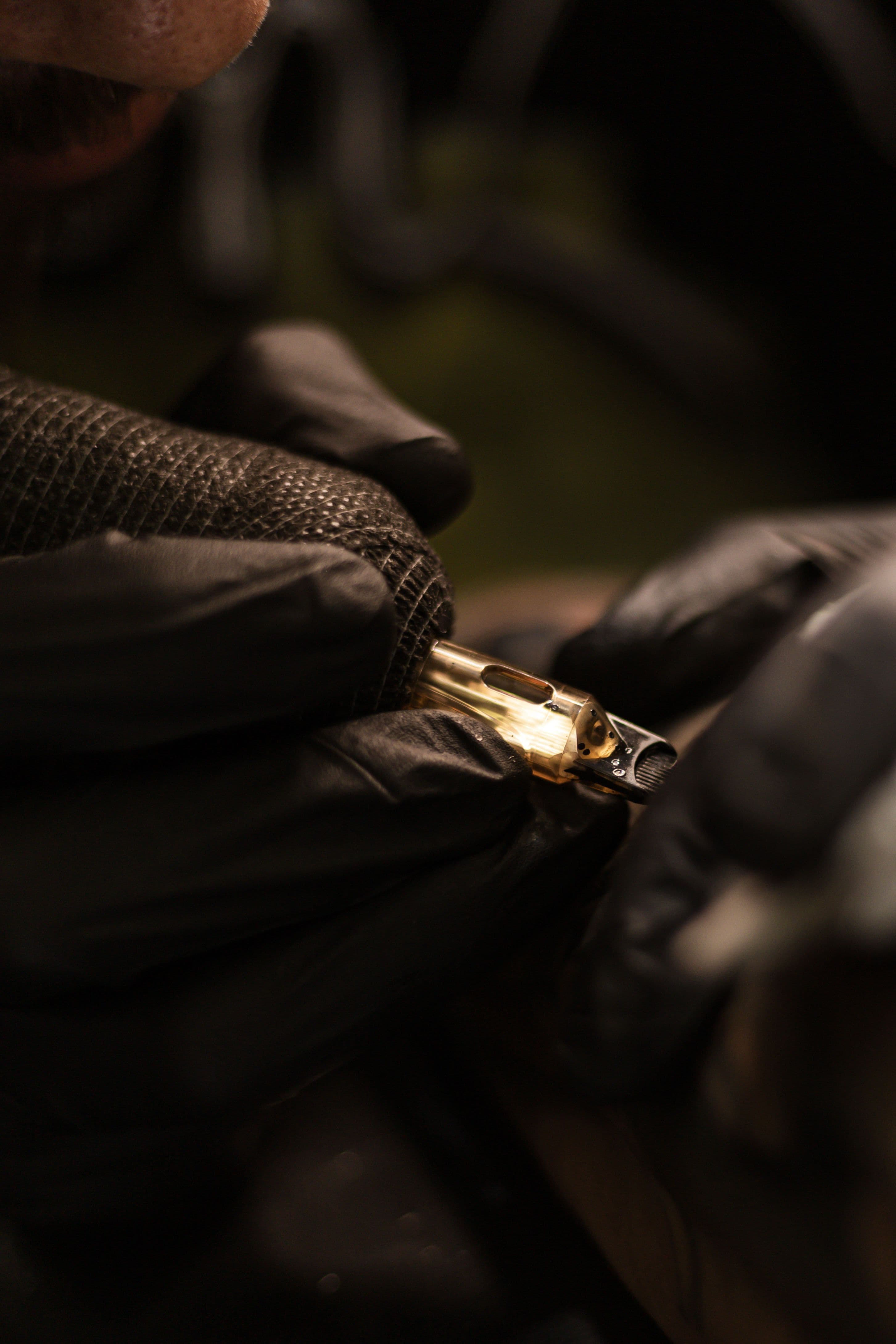 Extreme close-up of a hand loading a cartridge into a revolver cylinder.